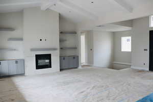 Unfurnished living room featuring a glass covered fireplace