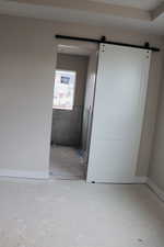 Unfurnished room featuring a barn door