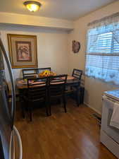 Dining space featuring wood finished floors, baseboards, and visible vents