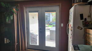 Doorway featuring water heater and french doors