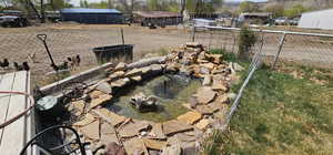 View of yard with fence and a garden pond