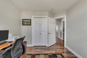 Office with baseboards, a textured ceiling, and wood finished floors