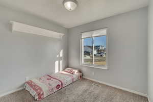 Unfurnished bedroom with visible vents, carpet floors, and baseboards