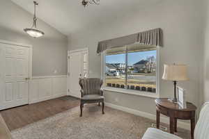 Living area with wainscoting, baseboards, lofted ceiling, and wood finished floors