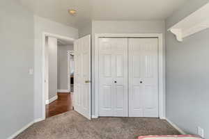 Unfurnished bedroom with carpet, baseboards, and a closet