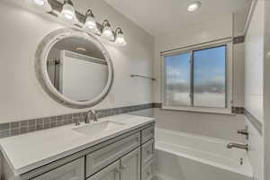 Full bath featuring a tub, visible vents, and vanity