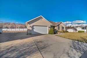 Ranch-style house with a front yard, fence, driveway, stucco siding, and brick siding