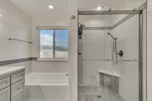 Bathroom with a bath, a stall shower, and vanity