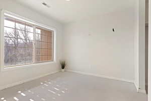 Empty room featuring visible vents and baseboards
