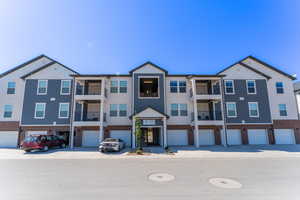 Multi unit property with board and batten siding, an attached garage, and brick siding