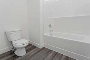 Bathroom with baseboards, toilet, and wood finished floors