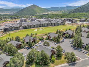 Aerial view of residential area with a mountain backdrop and a golf course