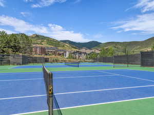 View of tennis court with a mountain view and community basketball court
