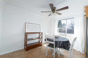 Dining space with a ceiling fan, baseboards, and ornamental molding