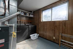 Washroom with laundry area, washer and dryer, and wood walls