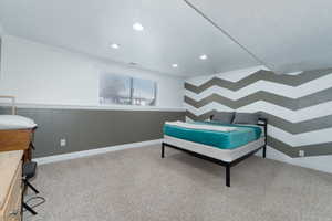 Carpeted bedroom with crown molding, recessed lighting, baseboards, and a textured ceiling
