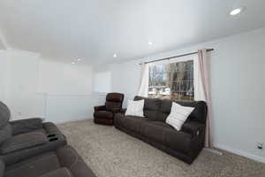 Living area featuring recessed lighting, crown molding, baseboards, and carpet floors