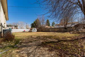 View of yard with an outbuilding, a storage unit, and a fenced backyard