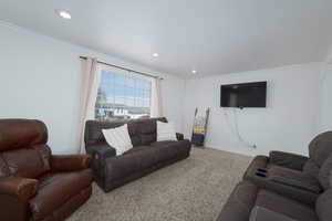 Living area with recessed lighting, baseboards, carpet flooring, and crown molding