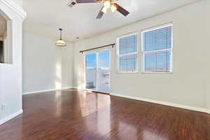 Empty room featuring sliding glass door, wood finished floors, baseboards, and ceiling fan