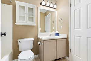 Bathroom featuring toilet, vanity, and tile patterned flooring