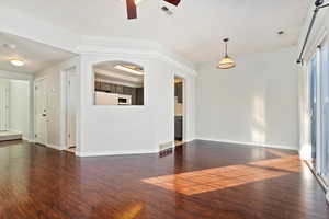 Unfurnished living room with dark wood-type flooring, and a ceiling fan