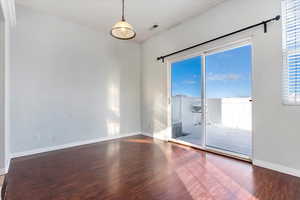 Empty room with wood finished floors, and baseboards, sliding glass door