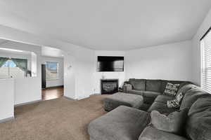 Carpeted living room featuring a fireplace and a wealth of natural light