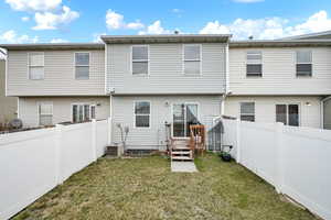 Rear view of house featuring a fenced backyard and sliding glass door