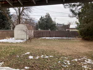 View of yard with an outbuilding, a storage unit, and a fenced backyard