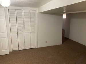 Unfurnished bedroom featuring a closet, carpet floors, and a textured ceiling
