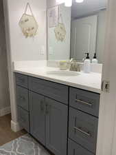 Bathroom featuring visible vents, vanity, baseboards, and wood finished floors