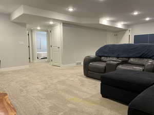 Living room with recessed lighting, visible vents, light colored carpet, and baseboards