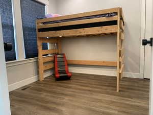 Bedroom featuring visible vents, baseboards, and wood finished floors