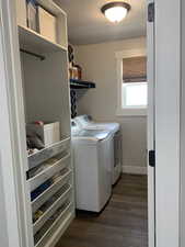 Washroom featuring laundry area, washing machine and dryer, a textured ceiling, and dark wood-style flooring