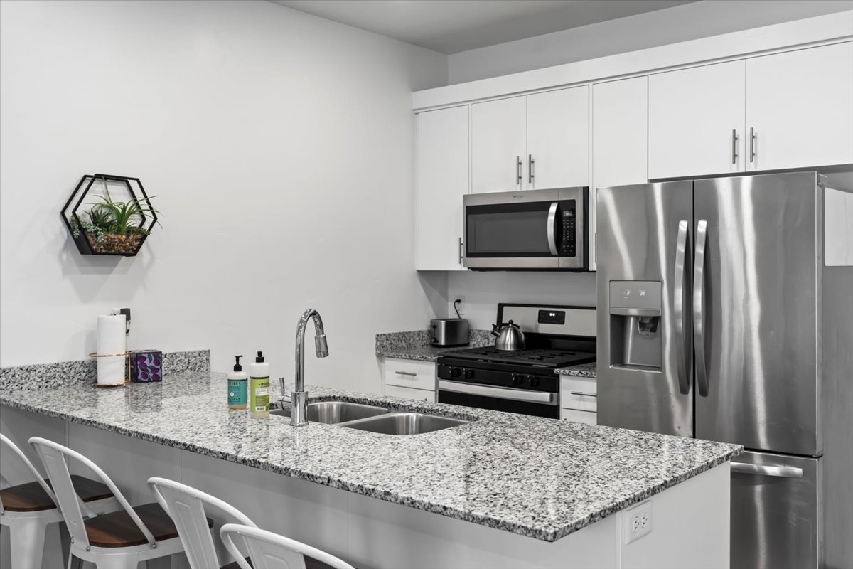 kitchen includes stainless appliances, granite counters, and a large pantry
