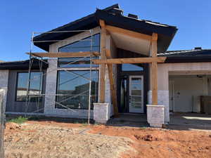 Doorway to property featuring driveway and stone siding