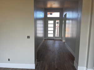 Doorway featuring dark wood-style flooring and baseboards