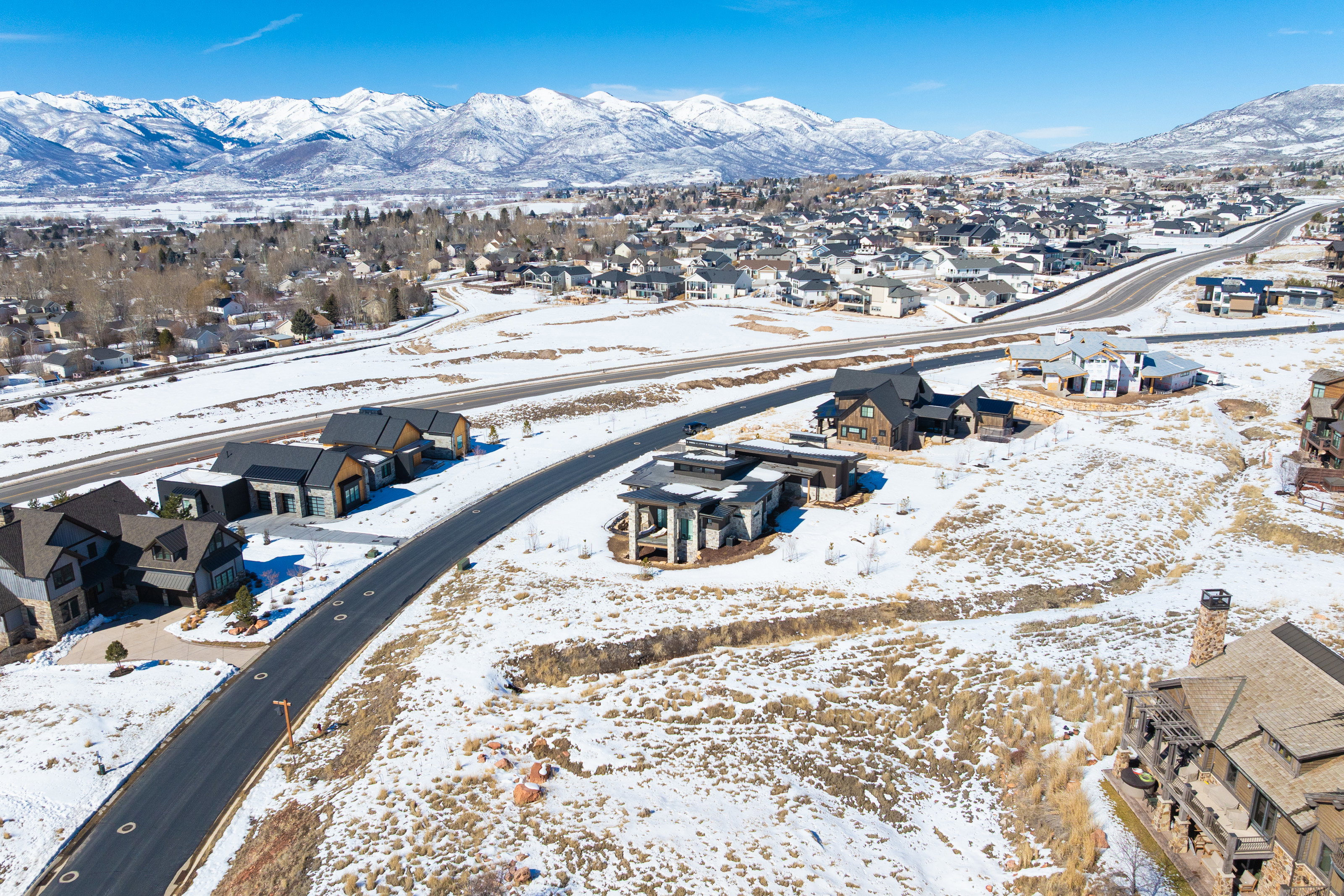 Aerial overview of property's location with nearby suburban area and a mountainous background