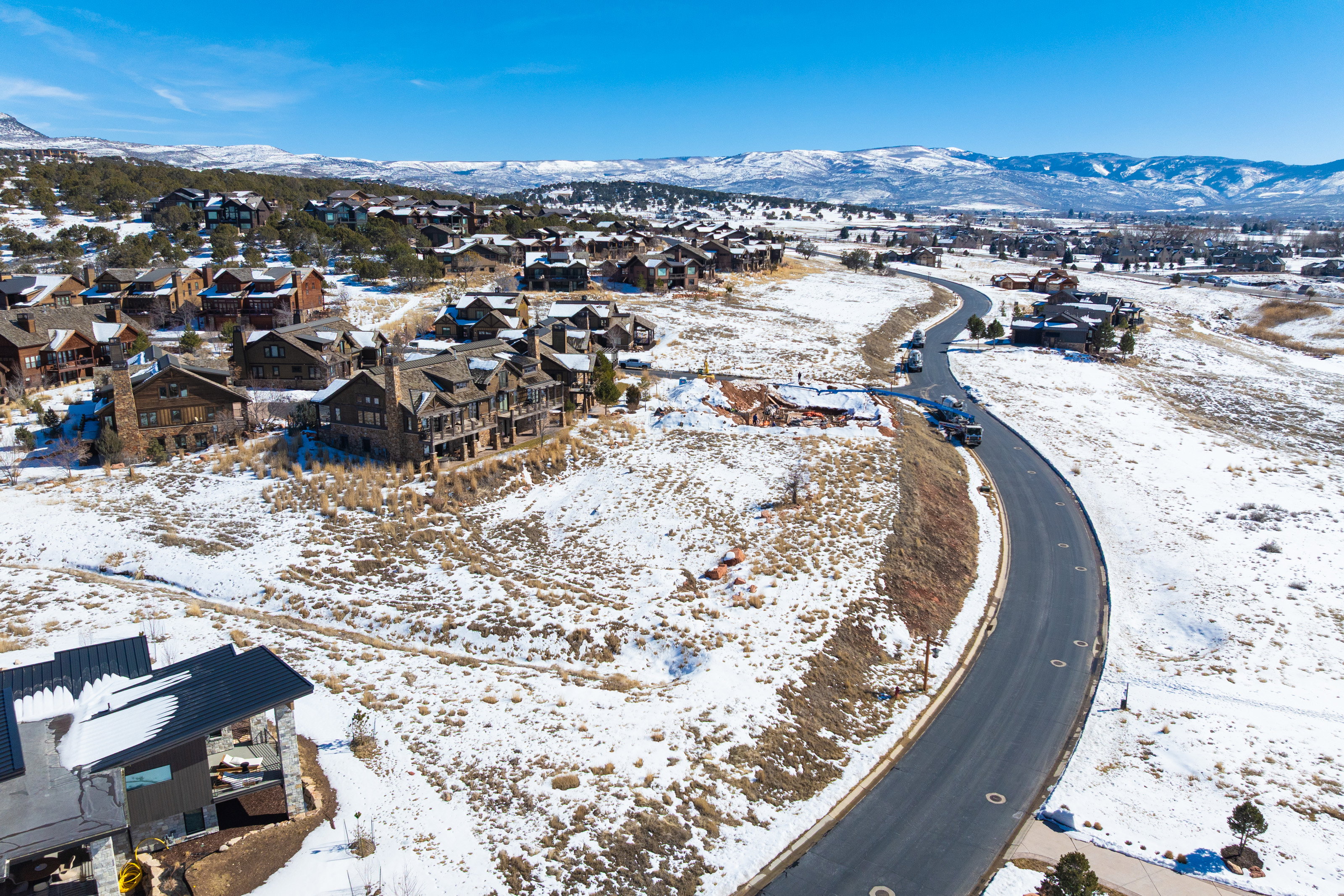 Snowy aerial view featuring a residential view and a mountain view