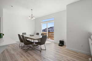 Dining room with an inviting chandelier, baseboards, and light wood-type flooring