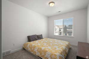Bedroom with visible vents, carpet, and baseboards