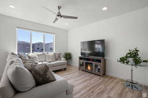Living room featuring light wood finished floors, recessed lighting, and ceiling fan