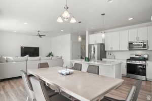 Dining space featuring stairs, light wood-style flooring, recessed lighting, and a ceiling fan