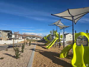 Community playground with fence and a residential view