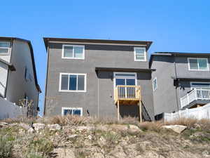 Rear view of property with stucco siding and fence