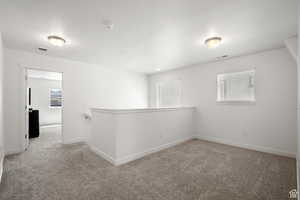 Carpeted empty room featuring baseboards and visible vents