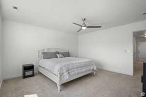 Bedroom with baseboards, light colored carpet, and a ceiling fan