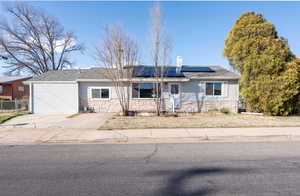 Front View of ranch-style home featuring solar panels.