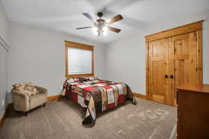 Carpeted bedroom with baseboards and a ceiling fan